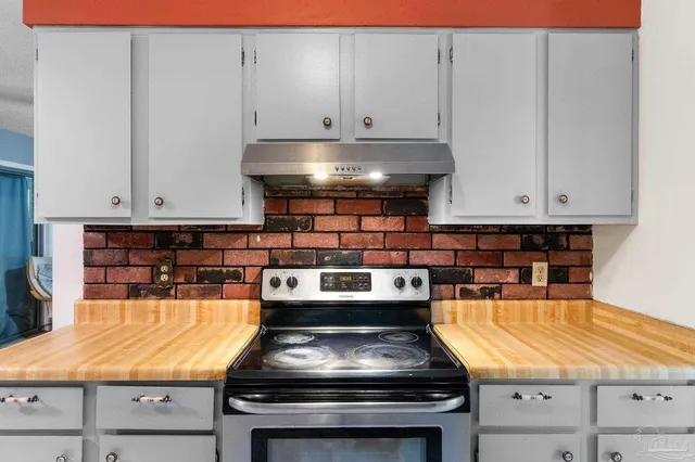 a kitchen with stove top oven and cabinets
