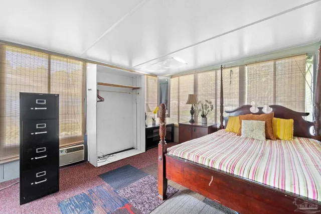 a large bedroom with a bed and wooden floor