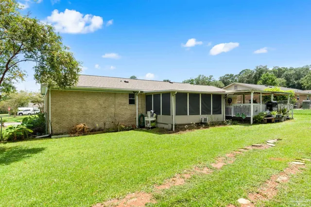 a view of a house with a yard and sitting area