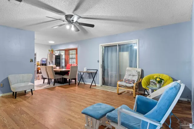 a living room with furniture chess table and a ceiling fan