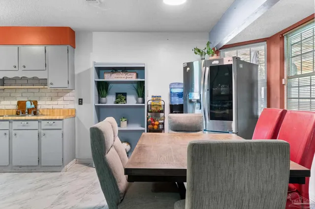 a living room with furniture kitchen view and a window