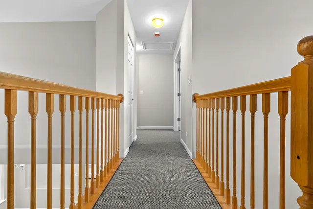a view of a hallway with wooden floor and windows