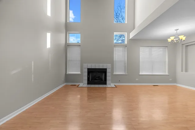 a view of an empty room with window and fireplace