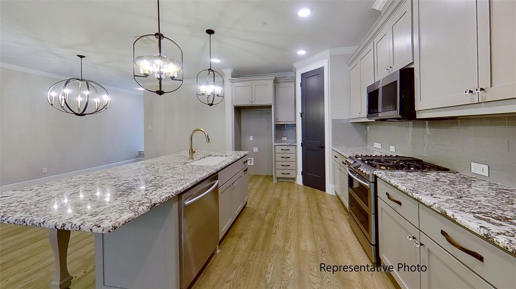 a kitchen with granite countertop stainless steel appliances lots of counter space and wooden floor