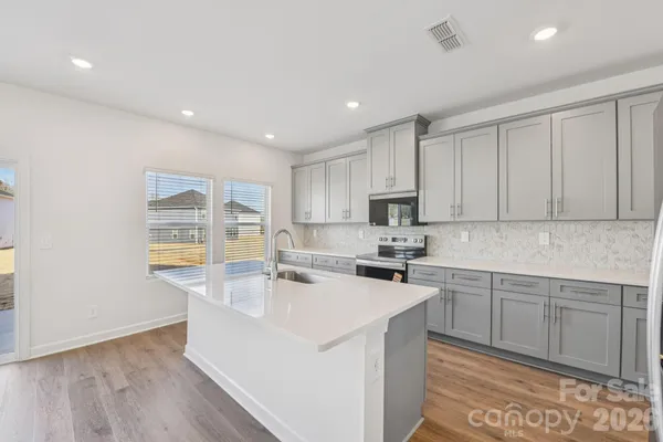 a kitchen with a sink cabinets and wooden floor