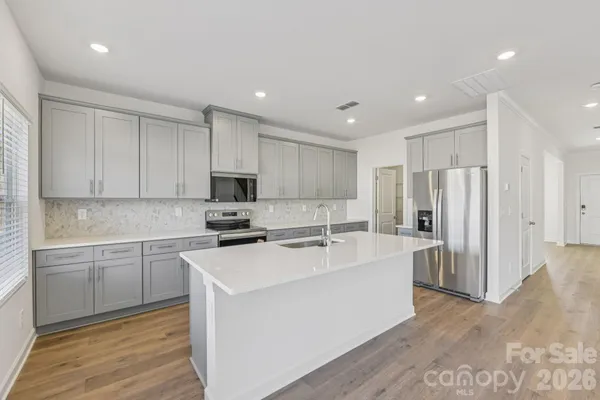 a view of a kitchen with a sink a refrigerator and cabinets