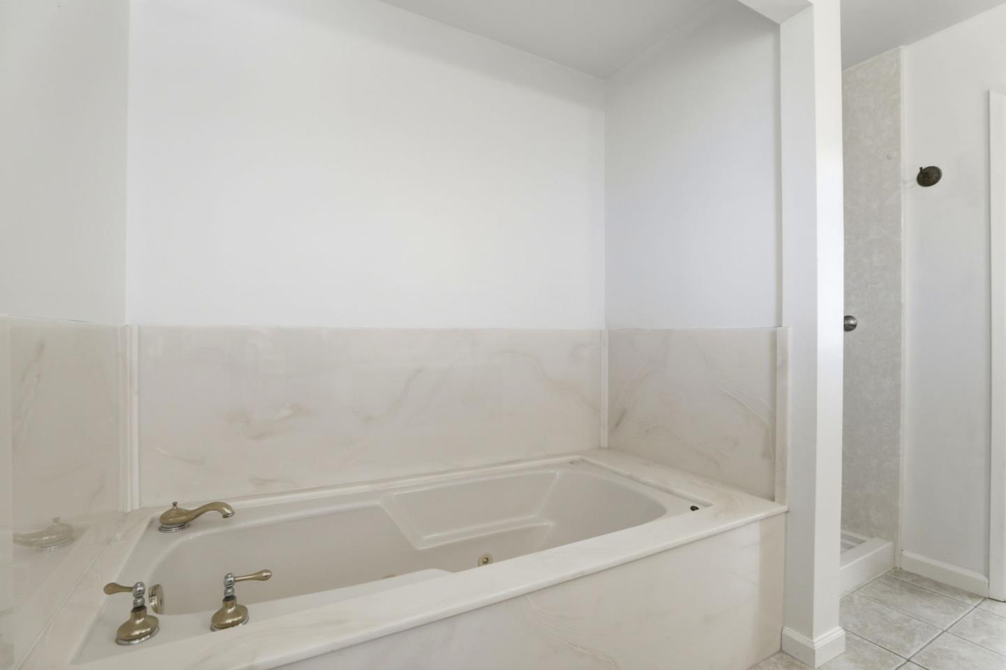 208 Mill Creek Road Fremont, CA 94539 - Photo 27 of 59 a white bath tub sitting next to a white sink and vanity