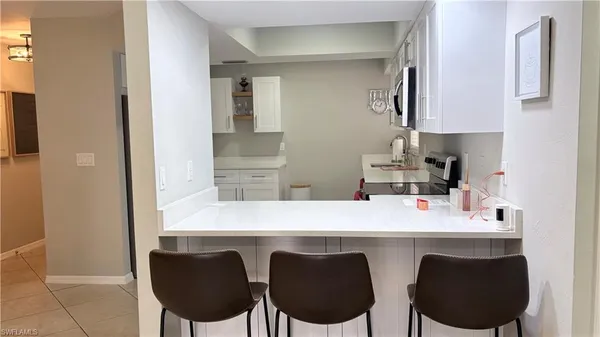 a kitchen with a dining table chairs and a refrigerator
