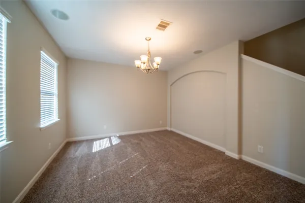 an empty room with windows and chandelier