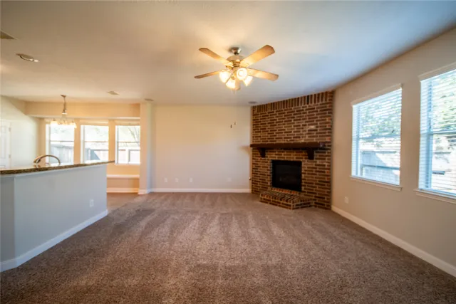 a view of an empty room with window and fire place