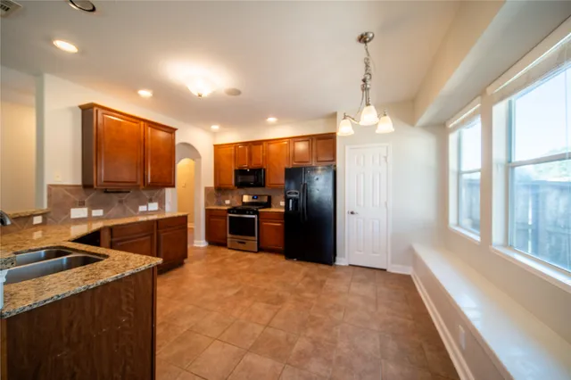 a kitchen with refrigerator a stove and a sink