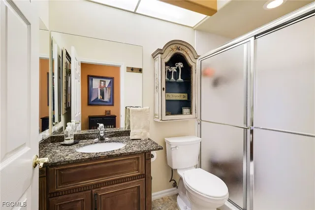 a bathroom with a granite countertop sink toilet and shower