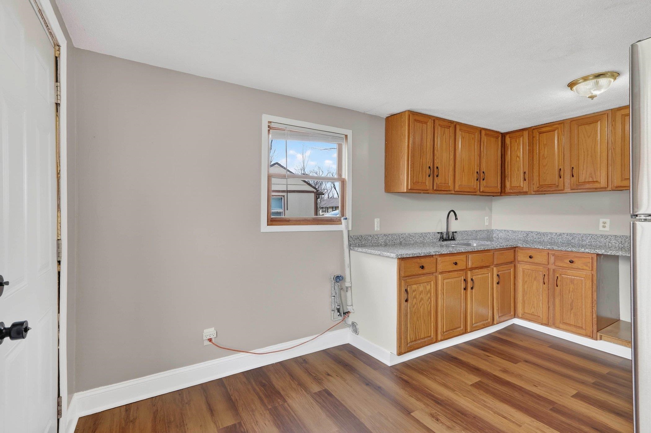 2120 Belden Street Rockford, IL 61101 - Photo 12 of 22 a kitchen with granite countertop a sink cabinets and wooden floor