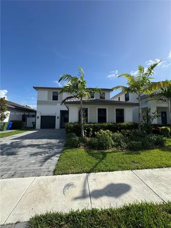 a front view of a house with a yard and potted plants