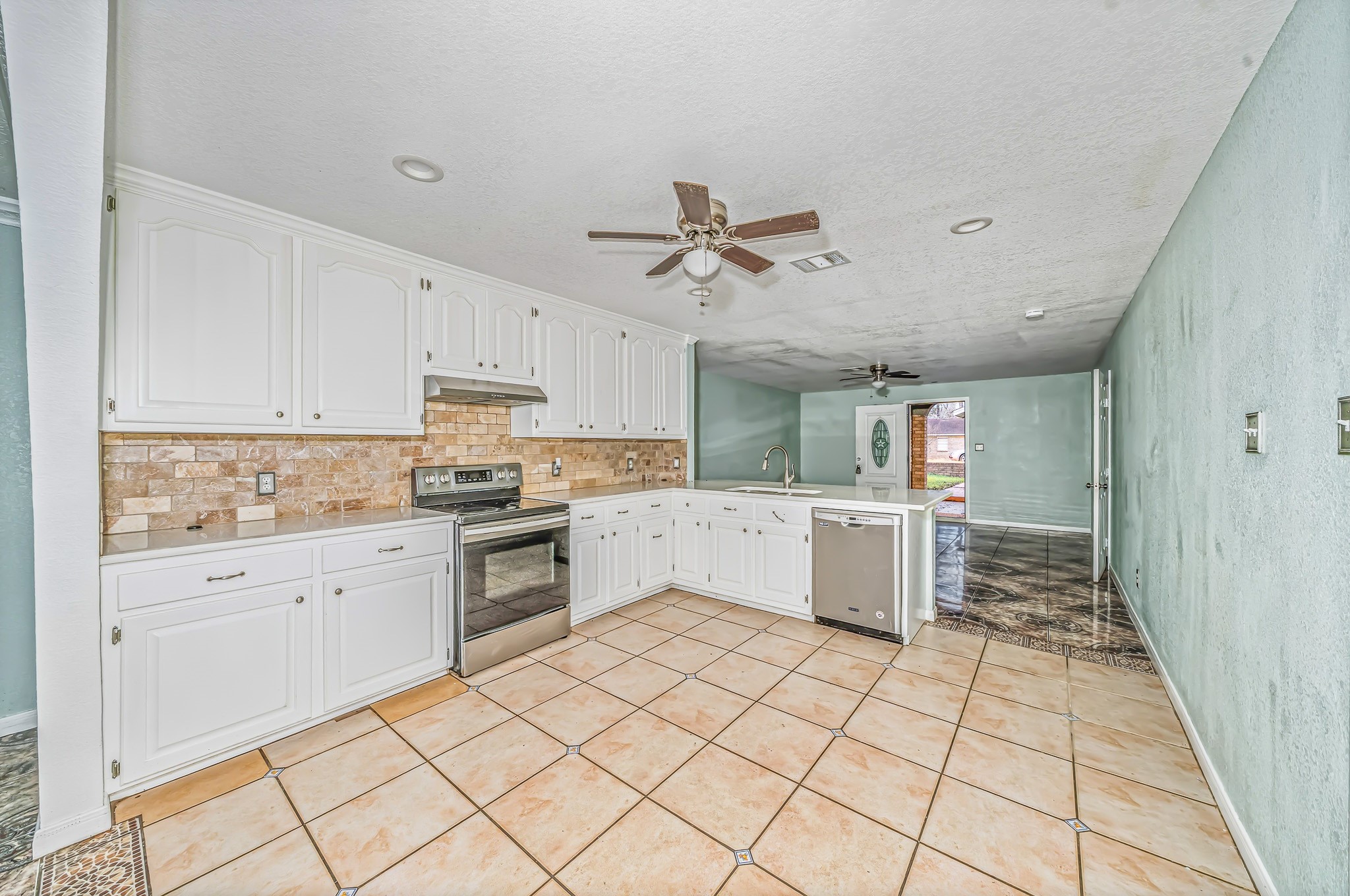 4771 Teas Court Conroe, TX 77304 - Photo 13 of 37 a kitchen with a stove a sink and a refrigerator