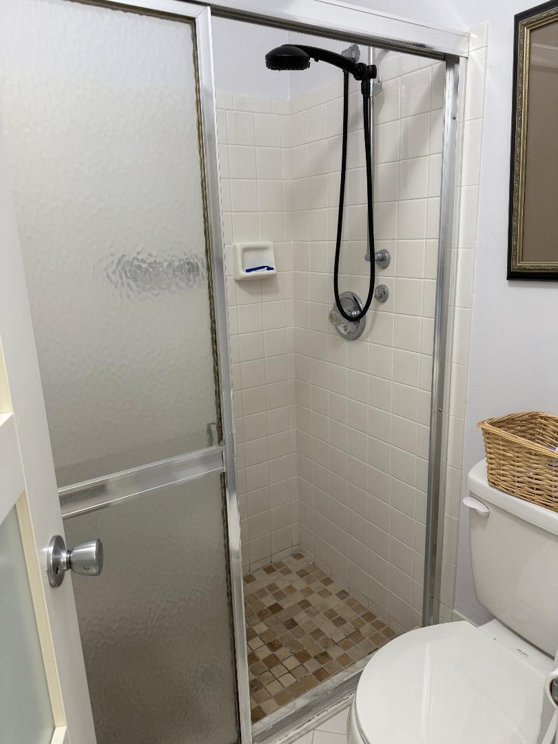 6217 Stanley Lane Delray Beach, FL 33484 - Photo 14 of 26 a bathroom with a granite countertop toilet and a shower
