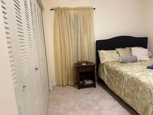 a spacious bedroom with a bed and a chair