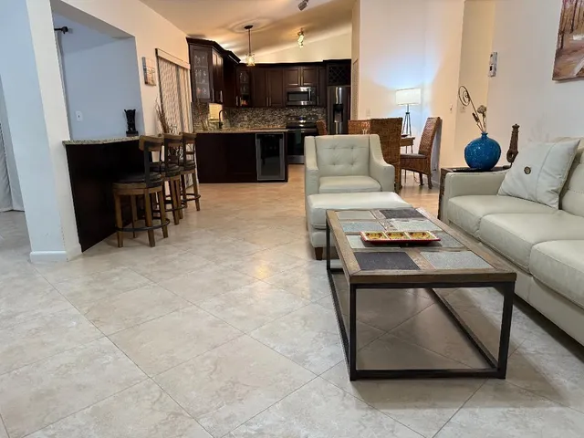 a living room with furniture and kitchen view