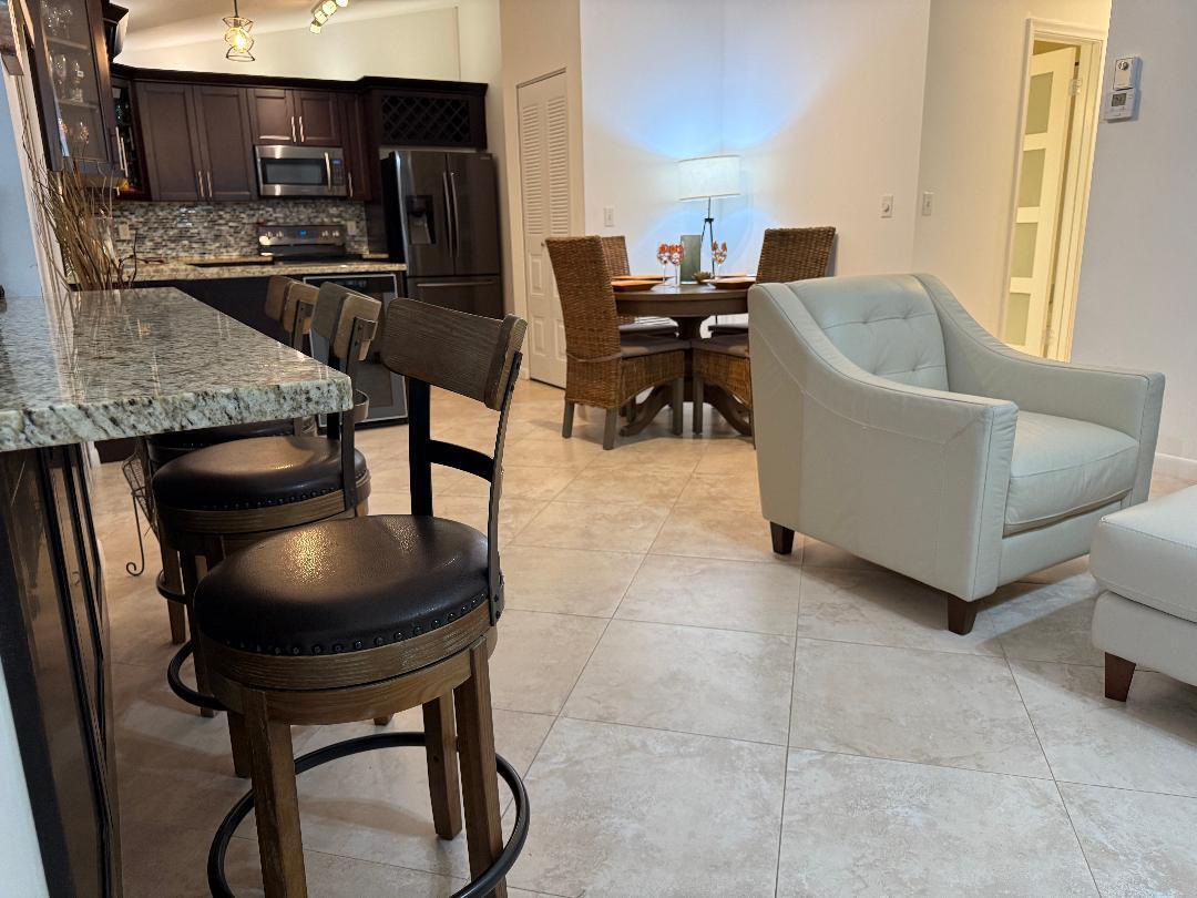 6217 Stanley Lane Delray Beach, FL 33484 - Photo 6 of 26 a kitchen with a table chairs microwave and refrigerator