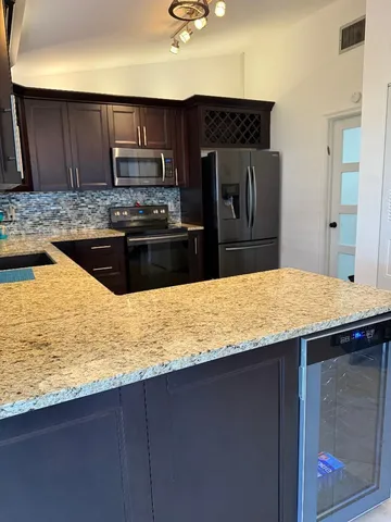 a kitchen with kitchen island granite countertop wooden cabinets and a granite counter top