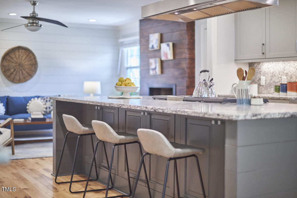 1502 Cassandra Drive Durham, NC 27712 - Photo 17 of 52 a kitchen with granite countertop a sink chairs and cabinets