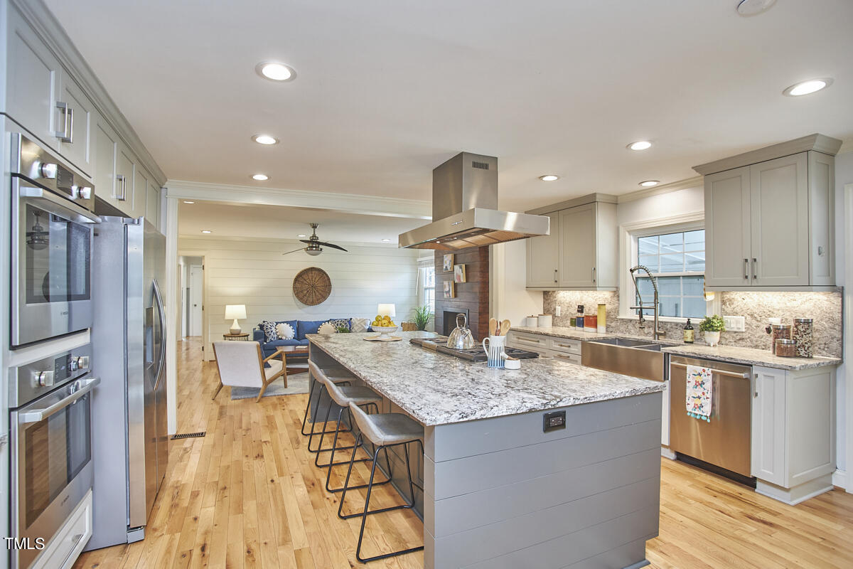 1502 Cassandra Drive Durham, NC 27712 - Photo 18 of 52 a kitchen with stainless steel appliances granite countertop a sink a stove and a wooden floors
