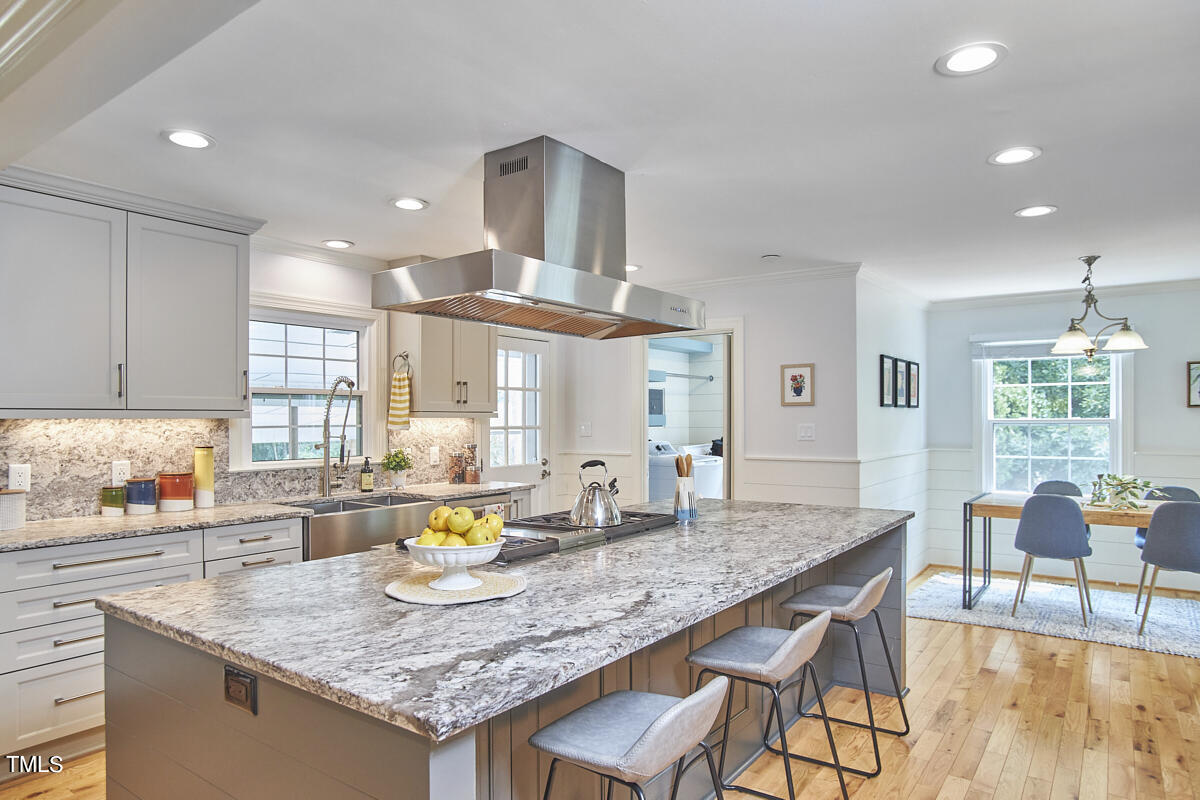 1502 Cassandra Drive Durham, NC 27712 - Photo 24 of 52 a kitchen with granite countertop kitchen island stainless steel appliances a dining table and chairs