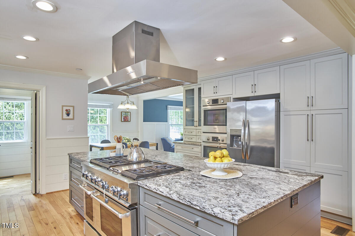 1502 Cassandra Drive Durham, NC 27712 - Photo 25 of 52 a kitchen with a stove a kitchen island a stove and a refrigerator