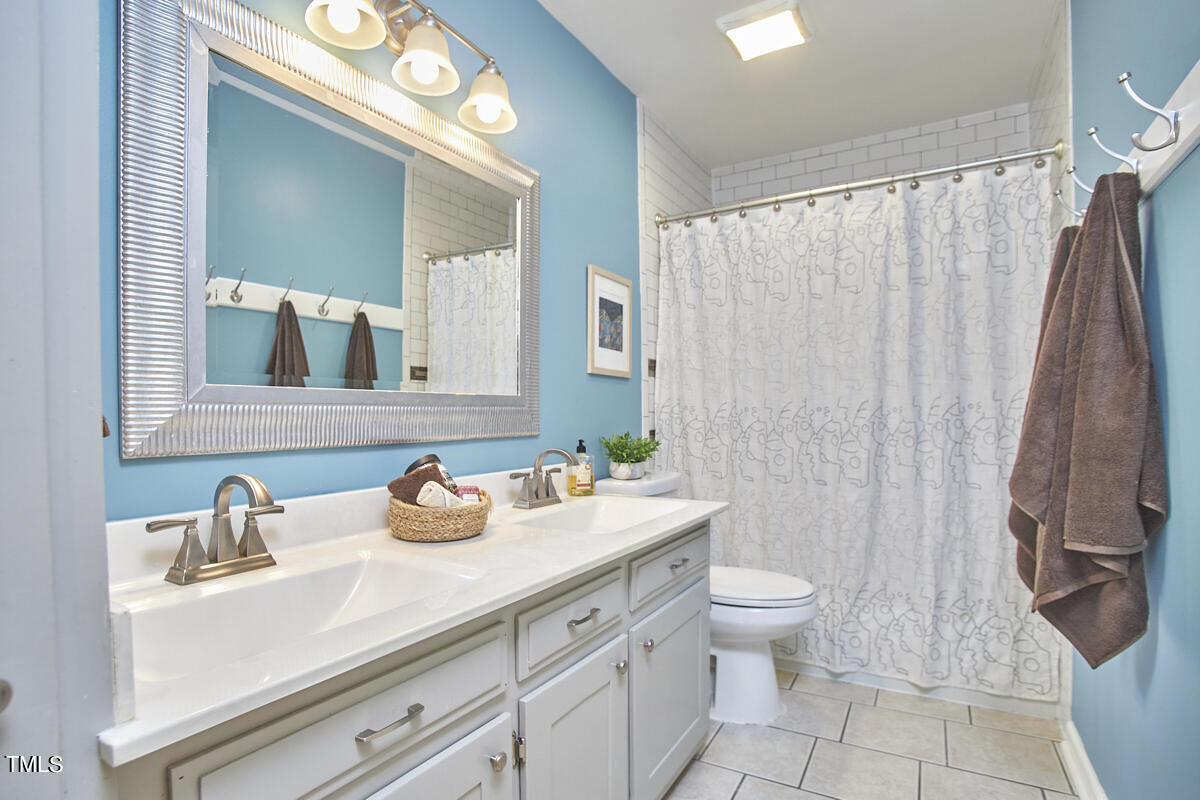 1502 Cassandra Drive Durham, NC 27712 - Photo 45 of 52 a bathroom with a sink a toilet and shower curtain