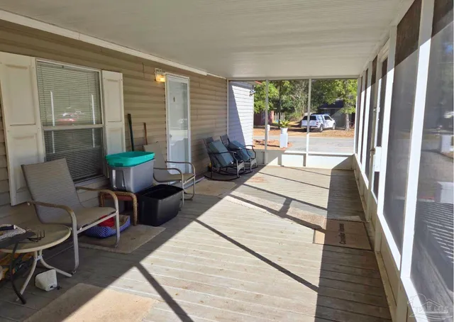 a living room with patio furniture and a wooden floor