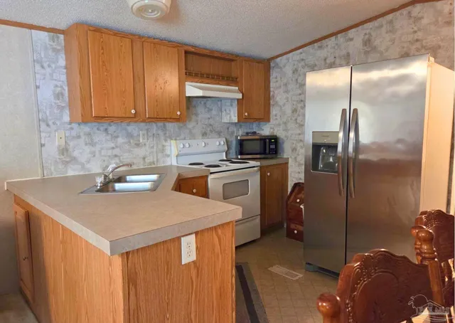 a kitchen with a sink a refrigerator and cabinets