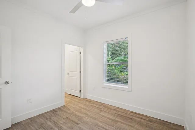 an empty room with wooden floor and windows