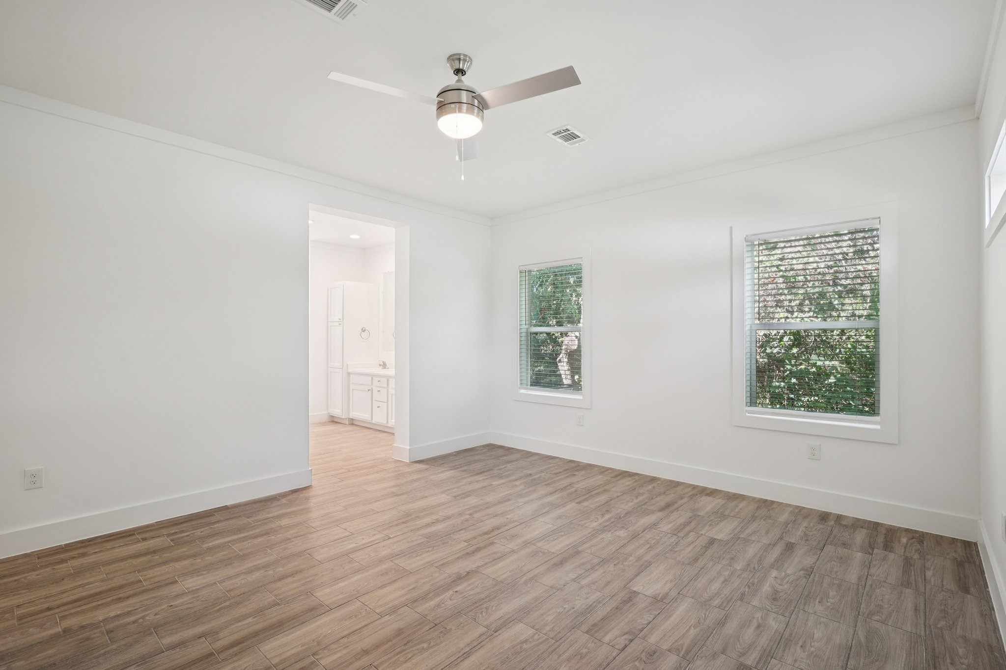 3917 Sayers Street Houston, TX 77026 - Photo 23 of 26 an empty room with wooden floor chandelier fan and windows