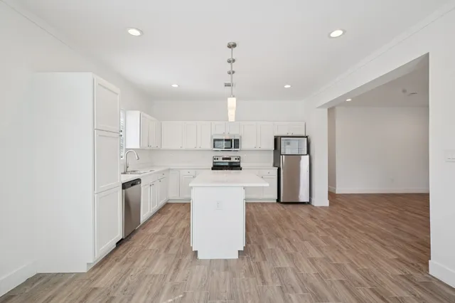a kitchen with refrigerator cabinets and wooden floor