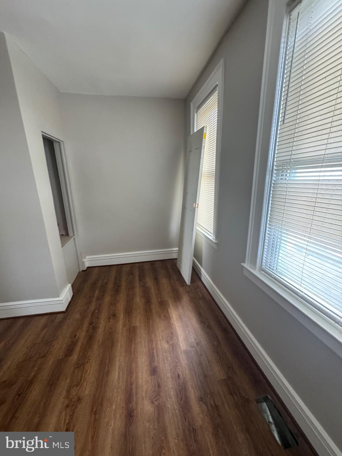 2613 Maisel Street Baltimore, MD 21230 - Photo 3 of 15 an empty room with wooden floor and windows