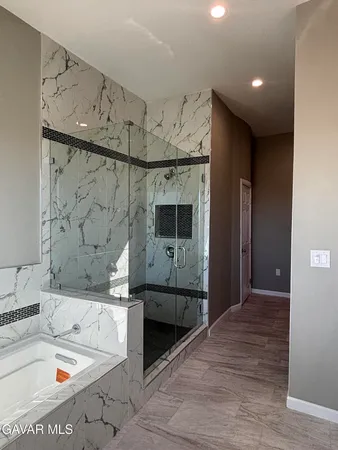 a bathroom with a tub a sink and a mirror