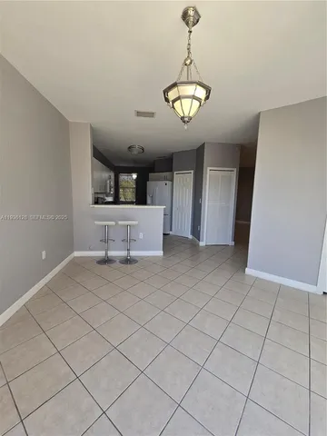 an empty room with windows and ceiling fan