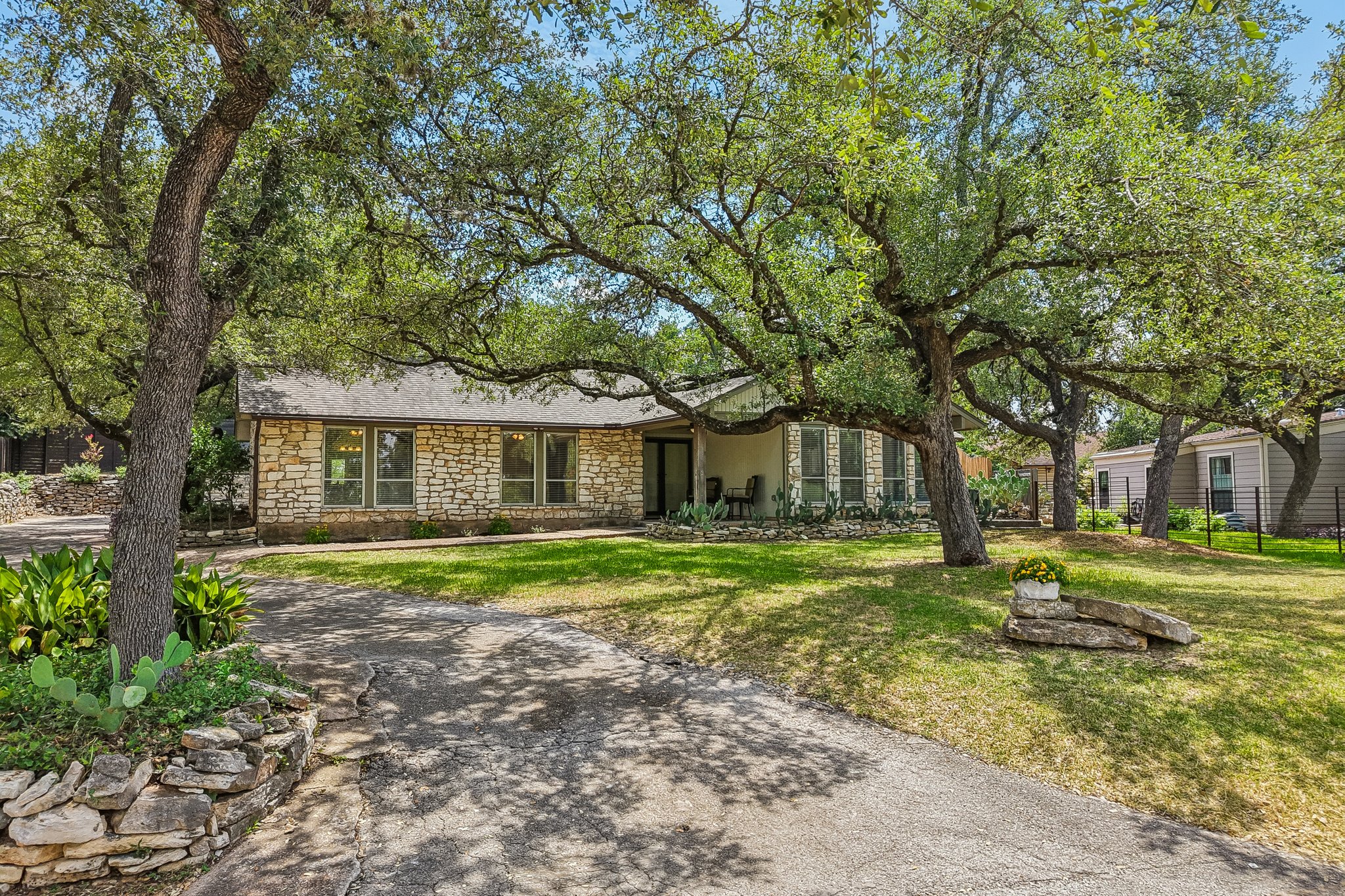 13101 Travis View Loop Austin, TX 78732 - Photo 20 of 27 Mature trees shade this inviting stone-clad ranch home with a welcoming front entry.