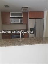 a kitchen with stainless steel appliances granite countertop a sink a stove and a microwave