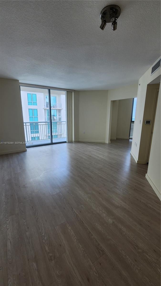 9066 Southwest 73rd Court, Unit 2003 Miami, FL 33156 - Photo 2 of 5 an empty room with wooden floor and windows