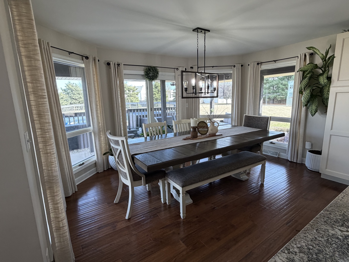 17245 County Line Road Plainfield, IL 60586 - Photo 7 of 45 a dining room with wooden floor a chandelier a wooden table and chairs