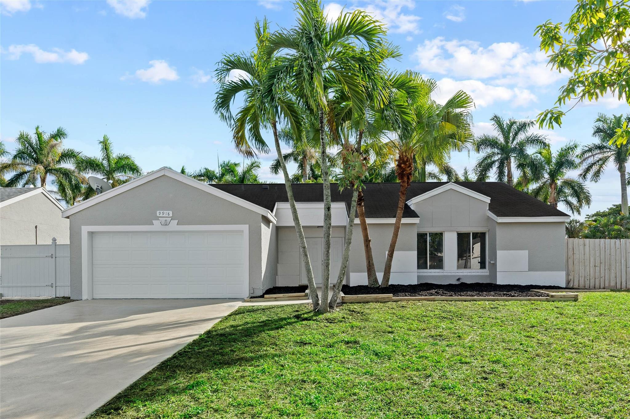 9918 Moss Pond Drive Boca Raton, FL 33496 - Photo 2 of 31 a front view of a house with a garden and trees