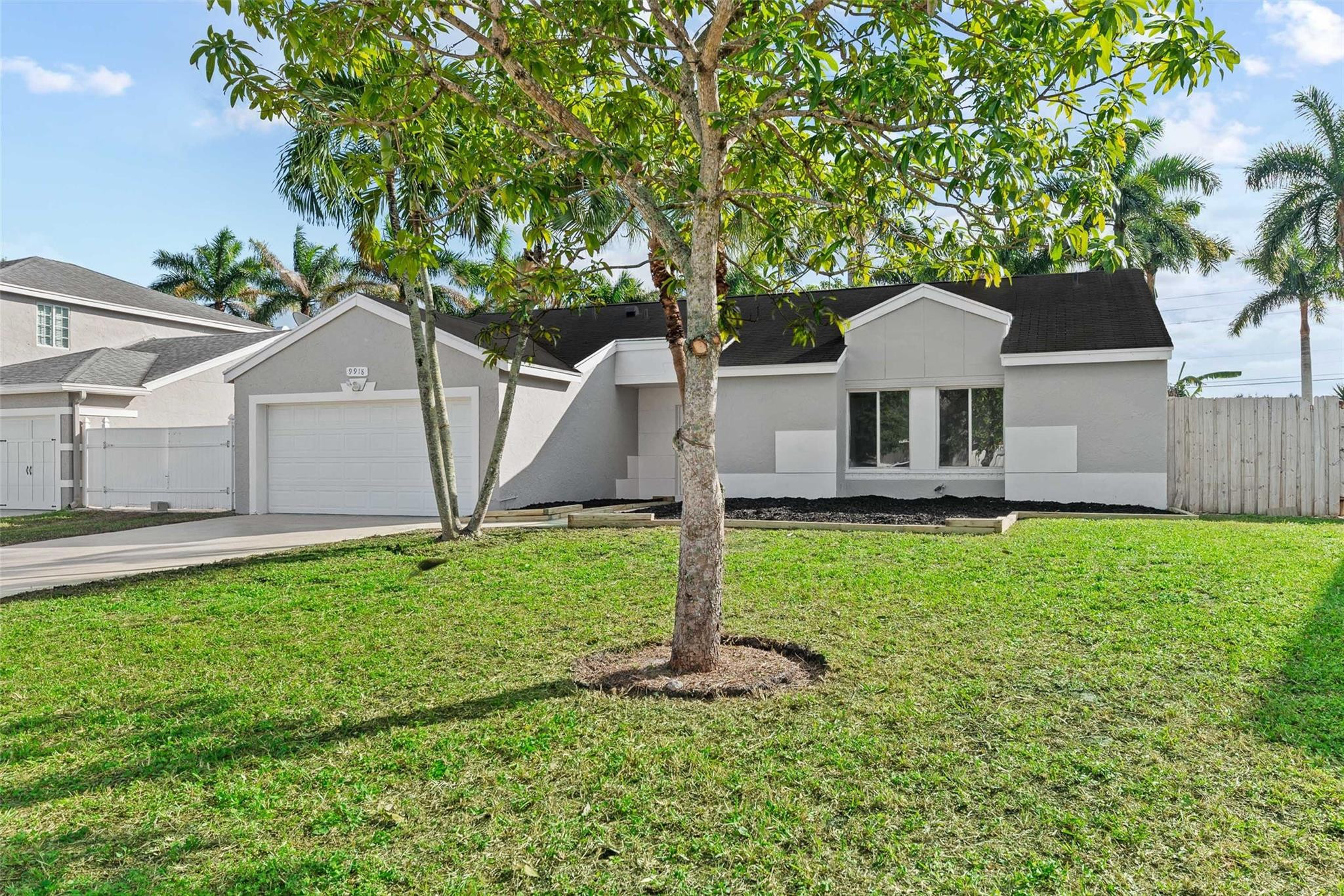 9918 Moss Pond Drive Boca Raton, FL 33496 - Photo 3 of 31 a front view of a house with a yard and trees