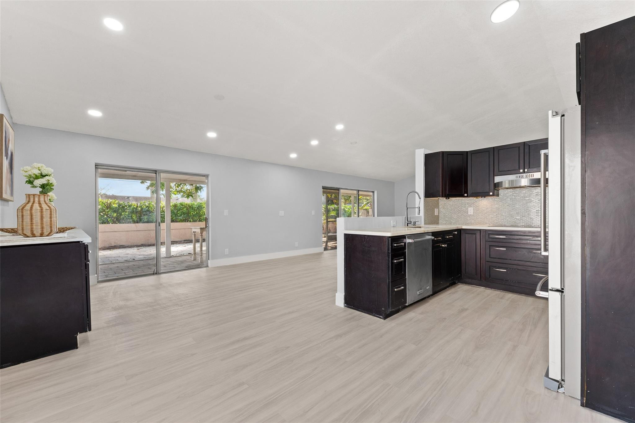 9918 Moss Pond Drive Boca Raton, FL 33496 - Photo 10 of 31 a kitchen with stainless steel appliances kitchen island granite countertop a stove a refrigerator a sink a oven with wooden cabinets and wooden floor