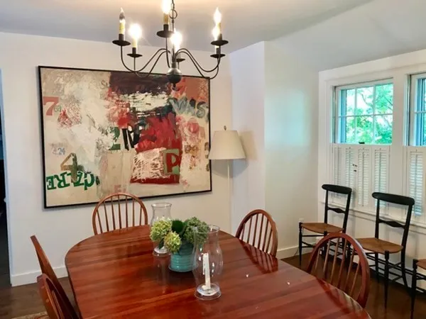 a view of a dining room with furniture one side and wooden floor