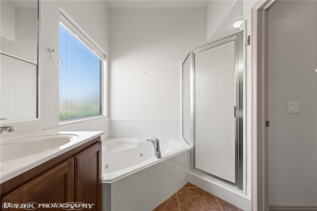 874 Glendale Road Mesquite, NV 89027 - Photo 40 of 71 Corner tub and shower complement the bathroom's functional layout and ample natural light.