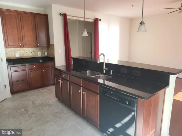 a kitchen with stainless steel appliances granite countertop a sink and a refrigerator