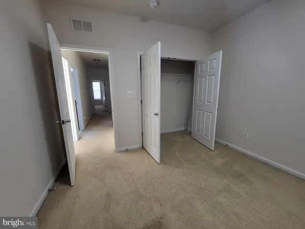an empty room with closet and mirror