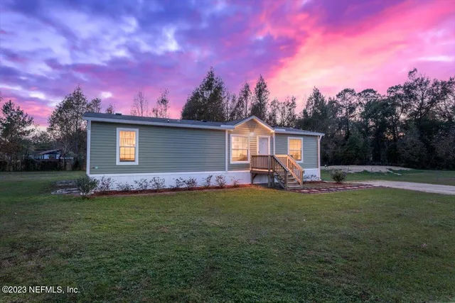 a view of a house with backyard and a tree