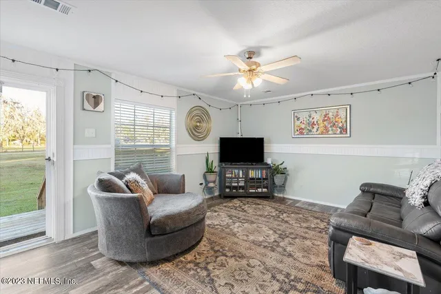 a living room with furniture a window and a flat screen tv